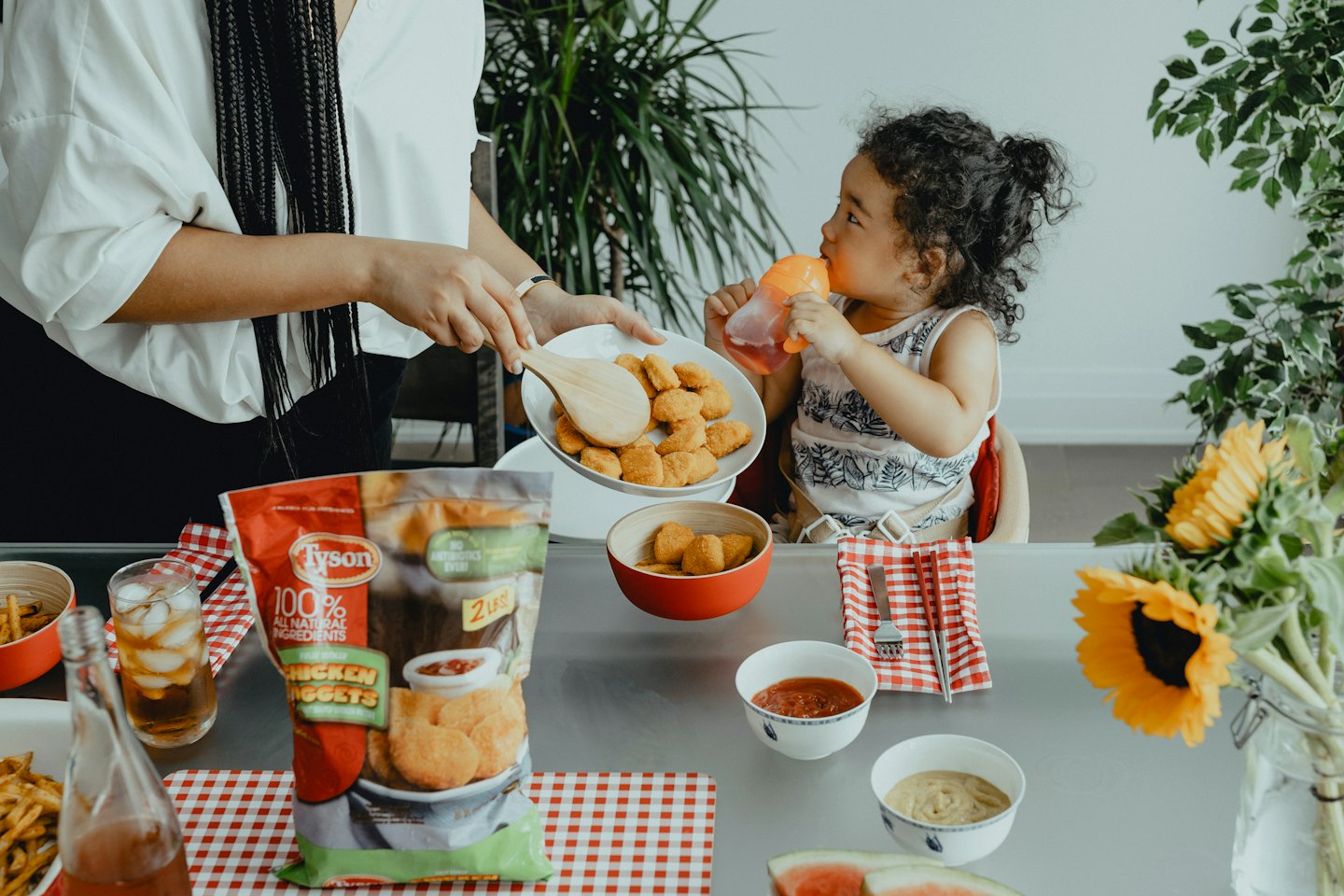 Serving golden chicken nuggets from a plate onto a table.