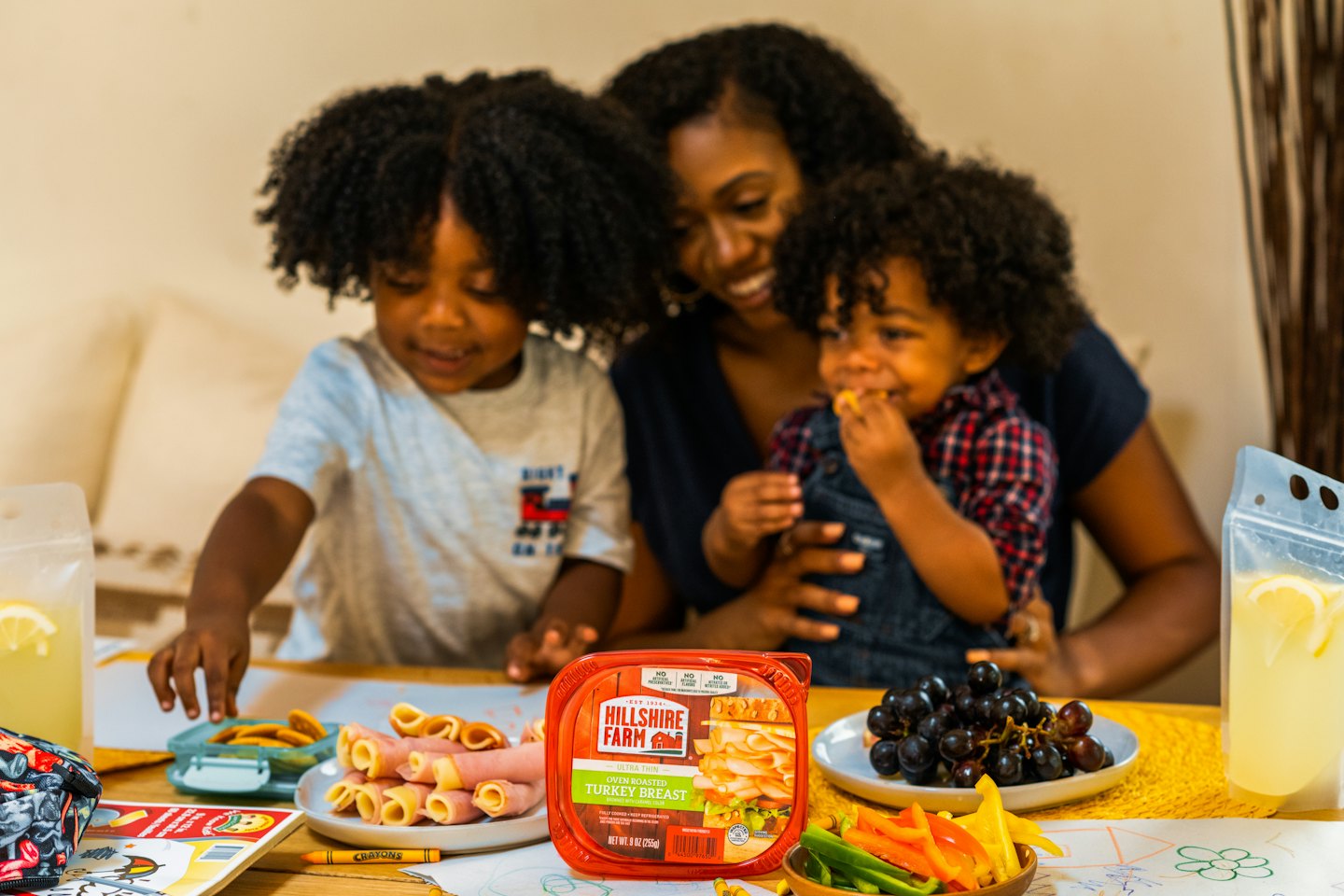 Mother and children enjoying a meal and drawing at a table.